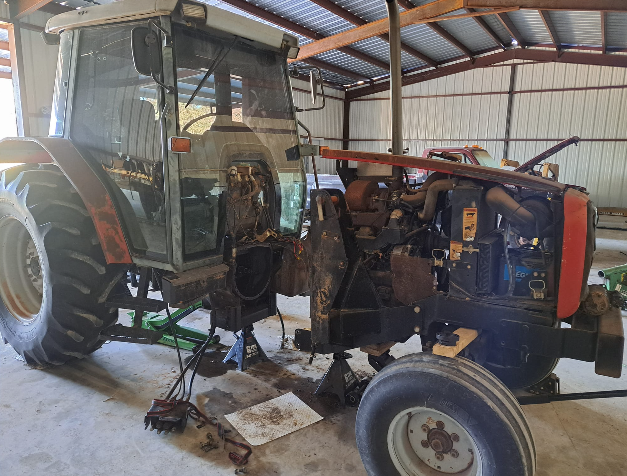 Equipment repair facility showing tractors being serviced in professional workshop environment