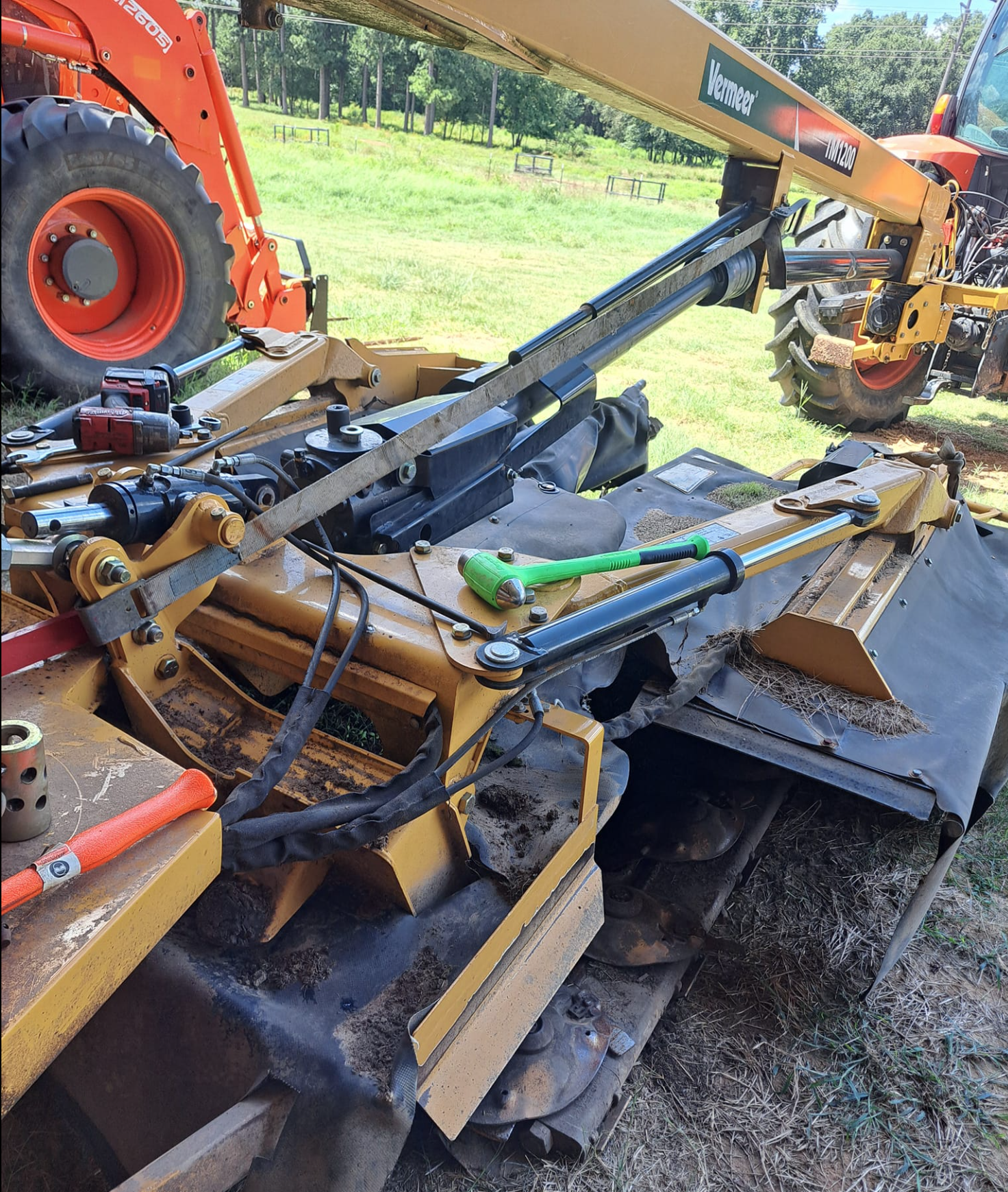 Mobile field service showing equipment hydraulic repair work in outdoor agricultural setting